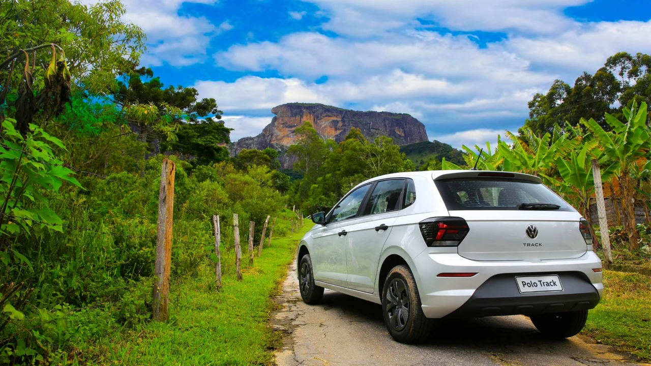 Foto de Volkswagen Polo Track visto de trás em estrada rural.