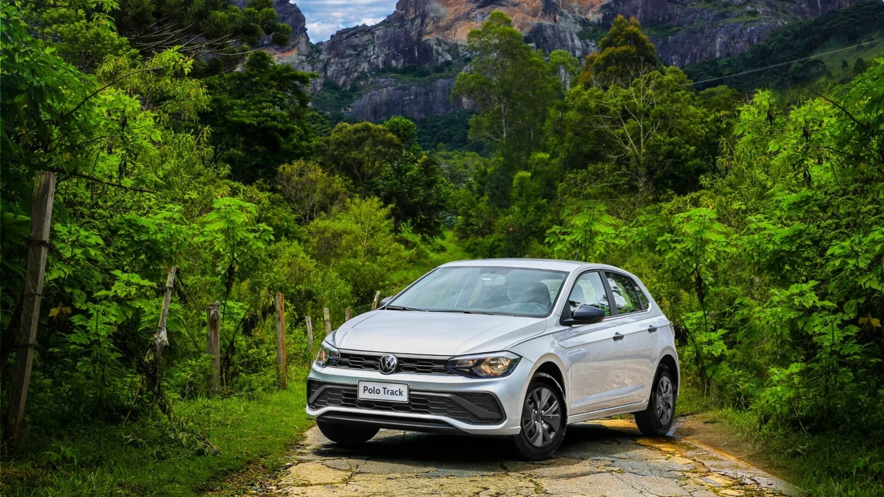 Volkswagen Polo Track prateado fotografado de frente em uma estrada com vegetação.